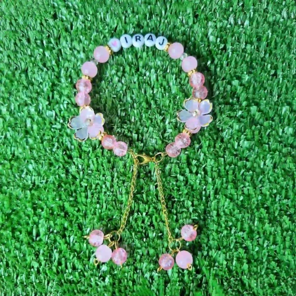 Pink handmade personalized name bracelet with flower beads and charm