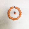 Orange minimalist handmade stretch bracelet displayed on neutral background